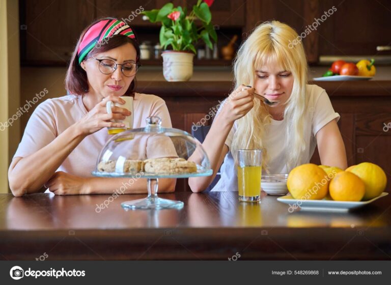 A parent and teenager having a conversation in the kitchen